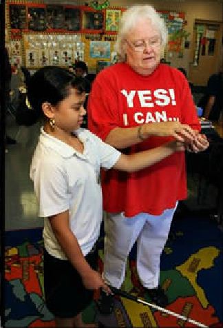 Becki Forsell teaching an elementary boy on using the white cane